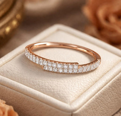 Rose gold moissanite curved wedding band with half eternity diamond style, minimalist stacking ring from Riora.