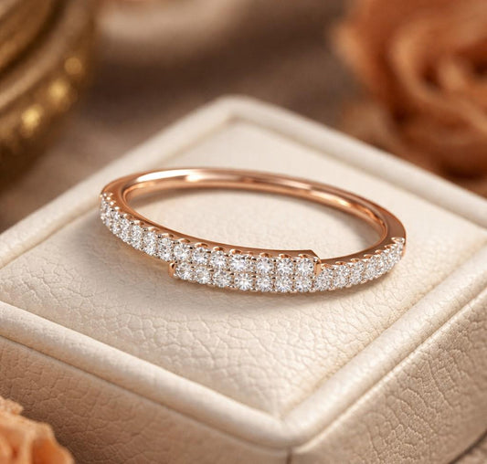 Rose gold moissanite curved wedding band with half eternity diamond style, minimalist stacking ring from Riora.