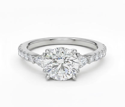Elegant CZ engagement ring by Riora featuring gold, rose, and silver tones, with sparkling gemstones and a delicate bridal design.