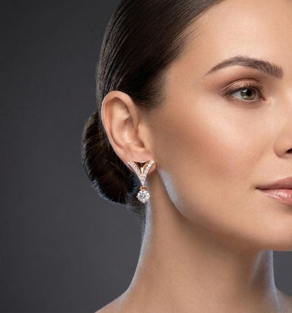 Riora Moissanite drop earrings in V-shape with rose gold and silver finish, featuring dangle design for bridal or wedding jewelry.