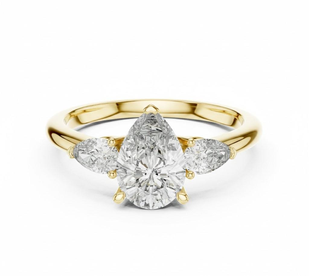 Pear cut cubic zirconia engagement ring by Riora with gold and silver bands, showcasing a sparkling center stone and elegant design.