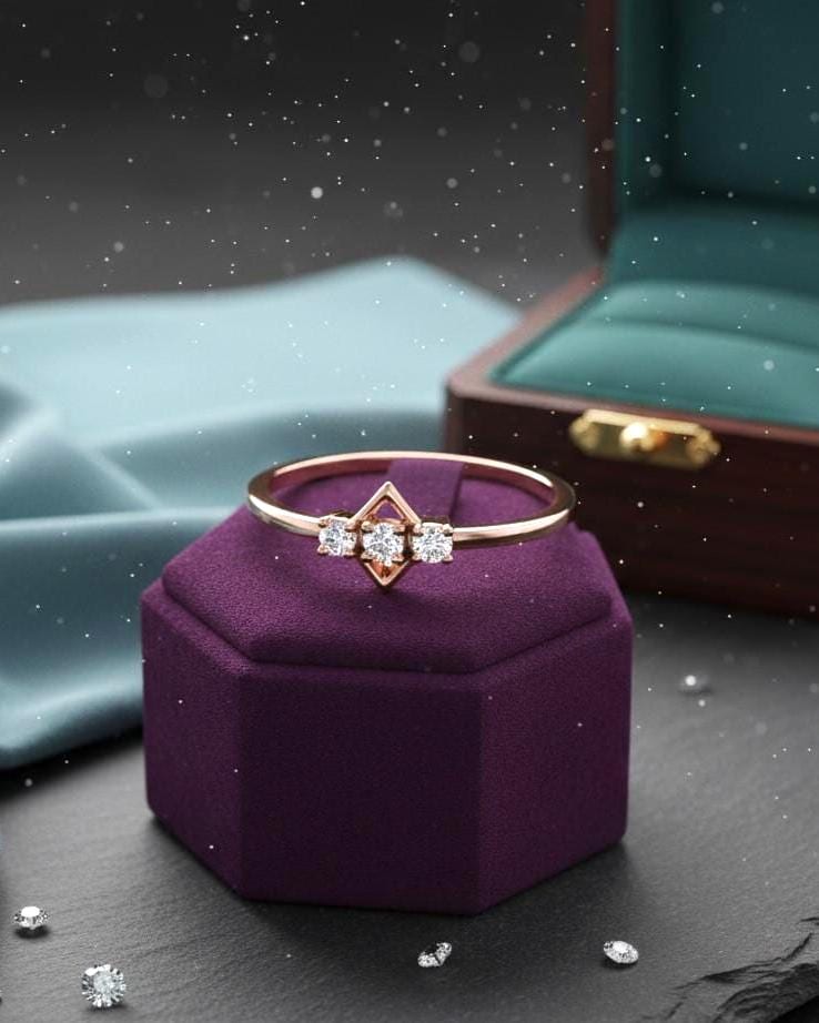 Rose gold three stone moissanite diamond ring with minimalist design, perfect for engagement or anniversary jewelry.