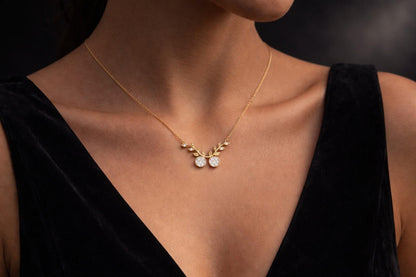 Rose gold and silver moissanite cherry branch necklace with leaf pendant, nature-inspired minimalist bridal jewelry by Riora.